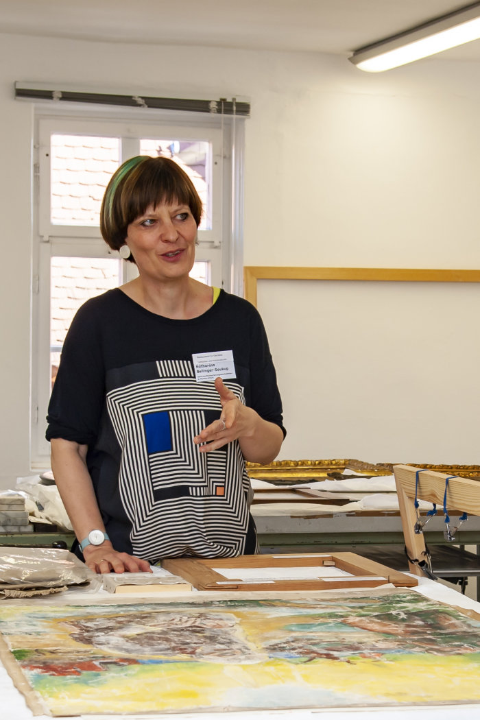 Gemälderestauratorin Katharina Bellinger-Soukup, Zentrale Restaurierungswerkstätten der Museen der Stadt Erfurt Eine Frau erklärt etwas an Gemälden