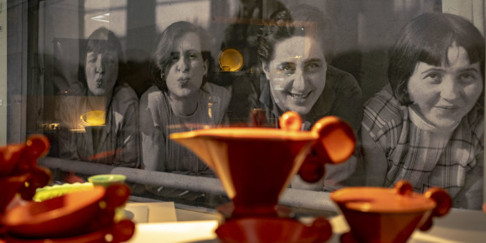Bild von vier Frauen, davor eine Vitrine mit einem Teeservice