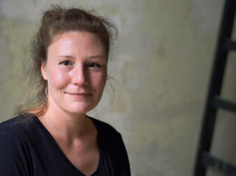 Porträt einer Frau mit zusammengebundenem Haar im schwarzen Oberteil