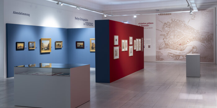 Blick in einen Raum mit verschieden farbigen Wänden und Bildern an der Wand