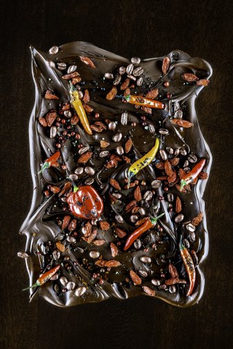 Foto: Mike Hofstetter: Roter scharfer Peperoni (aus der Serie: Salon du Chocolat) © Mike Hofstetter Foto einer Schokoladenplatte, verziert unter anderem mit Peperonis
