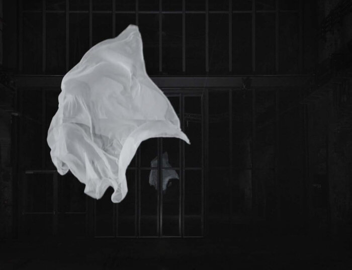 Edith Kollath, nothing will ever be the same (2009), Videostill, ©VG Bild-Kunst, Bonn 2022 Fliegendes weißes Tuch vor dunkler vergitterter Wand