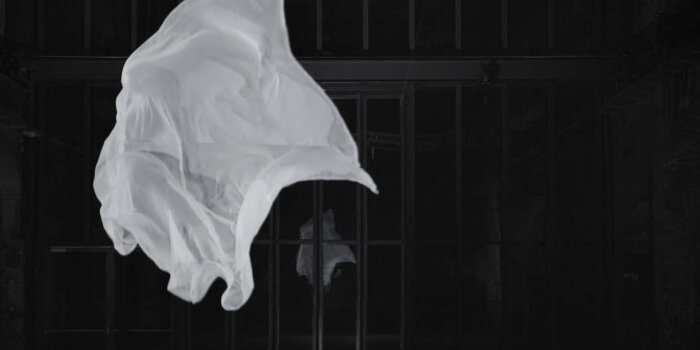 Foto: Edith Kollath, nothing will ever be the same (2009), Videostill, ©VG Bild-Kunst, Bonn 2022 © Gulliver Theis Fliegendes weißes Tuch vor dunkler vergitterter Wand