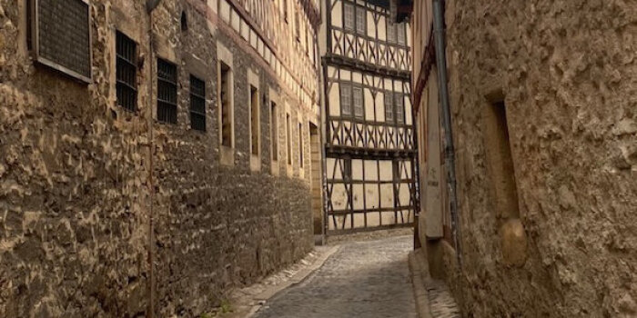 Foto: Teaser © Sarah Ordoñez Blick in eine sich verengende Gasse mit Fachwerkhäusern
