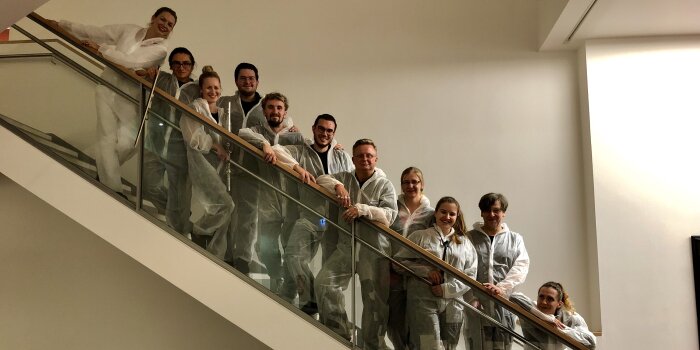 Menschen in weißen Anzügen auf einer Treppe stehend