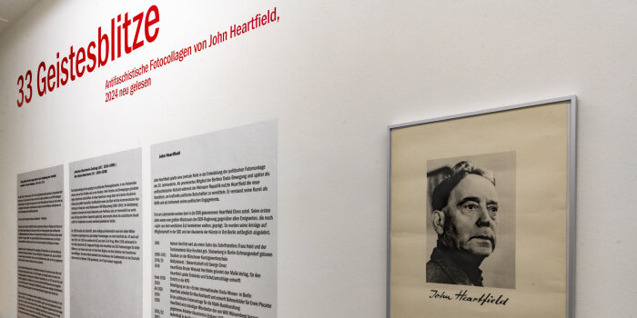 Eine Wand mit Text und ein gerahmtes Portrait eines Mannes