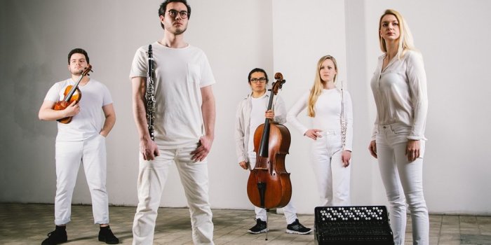 Drei Männer und zwei Frauen in weißer Kleidung mit ihren Instrumenten