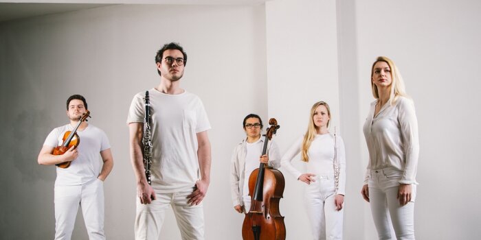 Drei Männer und zwei Frauen in weißer Kleidung mit ihren Instrumenten
