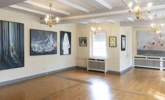Ein heller Raum mit vielen Gemälden
