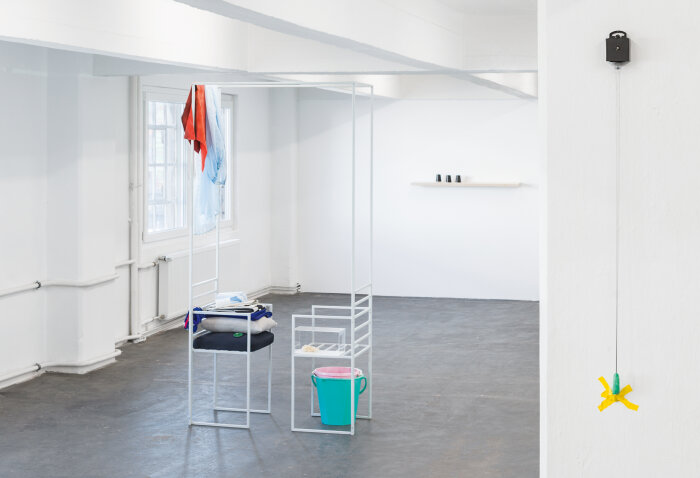Ausstellungsansicht, 2019 mit Werken von Julia Miorin und Franziska Paula Wolber Weißer Raum mit verschiedenen drapierten Möbeln und Alltagsgegenständen