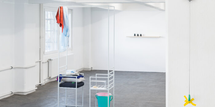 Foto: Ausstellungsansicht, 2019 mit Werken von Julia Miorin und Franziska Paula Wolber © Jakob Adolphi Weißer Raum mit verschiedenen drapierten Möbeln und Alltagsgegenständen