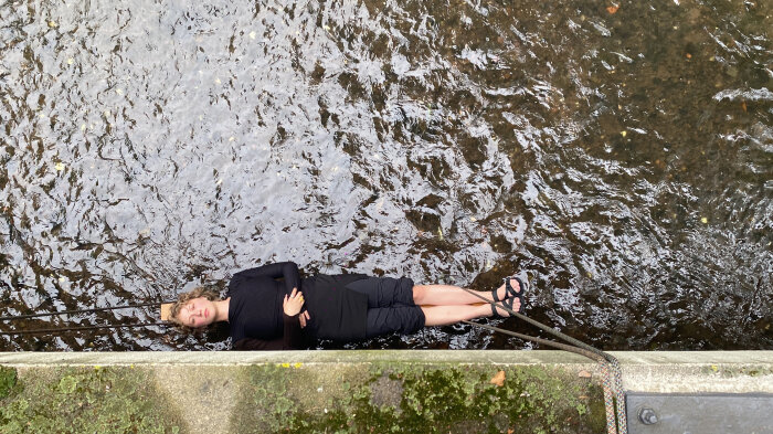 Lilien Augustin, Waagerechte II , 2021, Dokumentation der gleichnamigen Performance Eine Frau von oben fotografiert die über dem Wasser zu schweben scheint