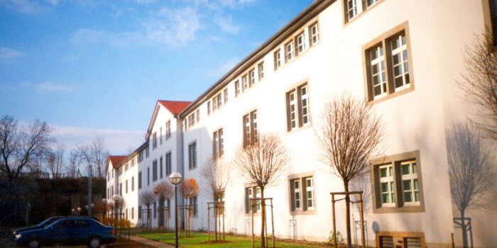 Das helle Gebäude der ehemaligen unteren Kaserne auf der Zitadelle Petersberg im Licht der Morgensonne