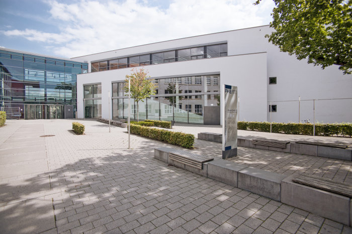Haus 8 am Campus der FH Außenansicht von Haus 8 an der Fachhochschule: Modernes Gebäude mit heller und verglaster Außenwand.