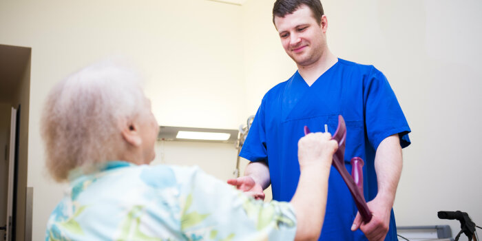 Foto: Geriatrie © Helios Kliniken GmbH Pfleger hilft älteren Frau Aufstehen