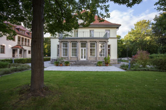 Gästehaus der Stadt Erfurt Das Foto zeigt den Hintereingang in einen Wintergarten eines mehrstöckigen Gebäudes.