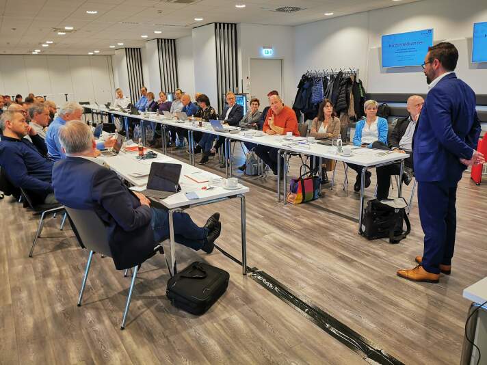 Personen an einem Konferenztisch in einer Beratungssituation