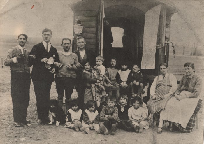 Willy Blum (Bildmitte) auf dem Arm seiner Schwester Schwarz-Weiß Foto von zehn Kindern und sechs Erwachsenen