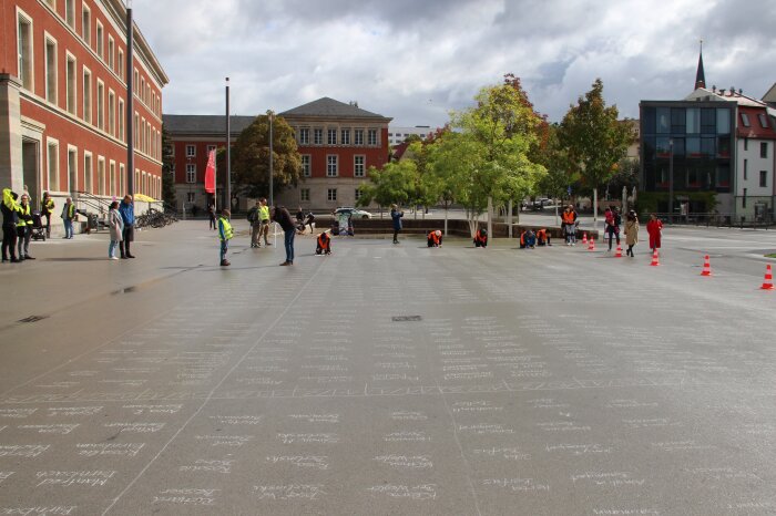 Über 2.000 Namen der Ermordeten, von vielen Bürgerinnen und Bürgern am 19. September 2022 mit Kreide auf dem Stéphane-Hessel-Platz in Weimar geschrieben Viele Menschen die Namen auf einen Platz schreiben