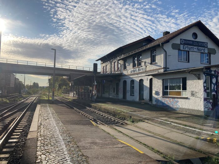 Nordbahnhof Schienen vor einem Bahnhofsgebäude, im Hintergrund ist eine Brücke zu sehen