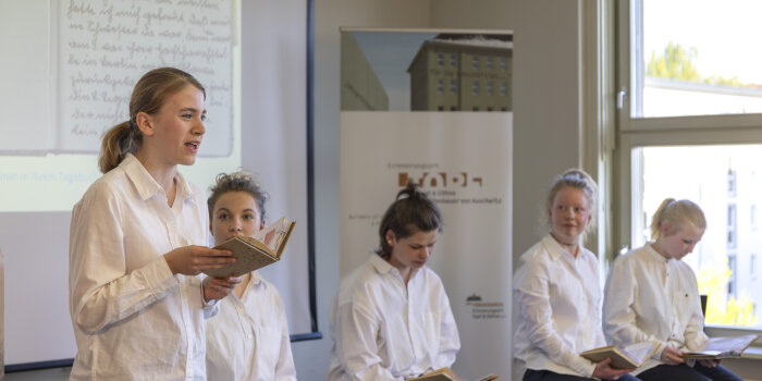 Foto: Szenische Lesung Miriams Tagebuch © Stadtverwaltung Erfurt fünf Mädchen in weißen Blusen, eines von ihnen liest aus einem Buch vor