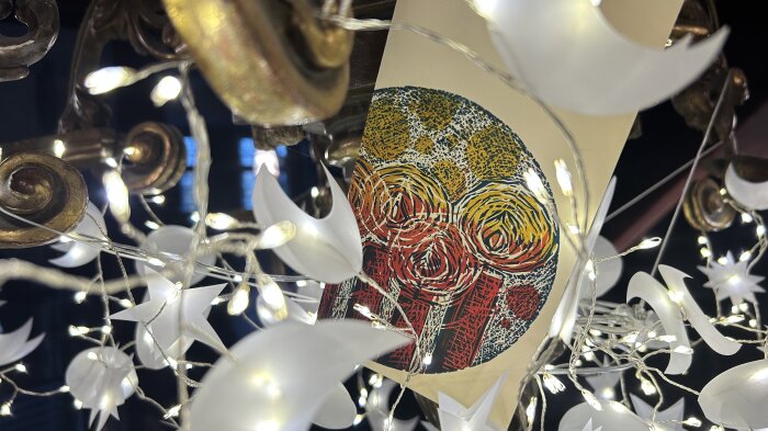 Kronleuchter weihnachtlich dekoriert mit Karte beleuchtete Lichterkette mit Sternen und Monden, dzwischen eine Karte mit weihnachtlichen Motiv
