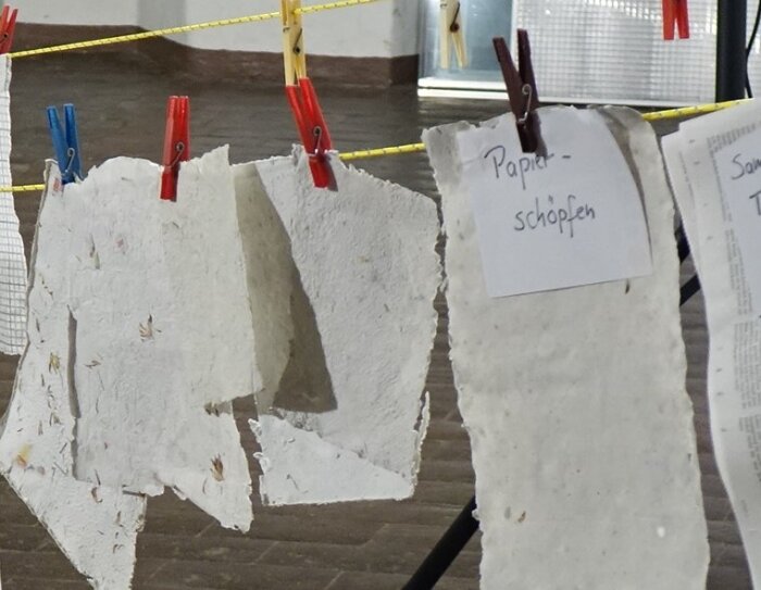 Rund ums Papier Geschöpftes Papier mit Klammern auf einer Leine