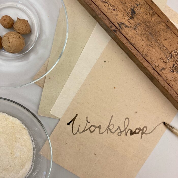 Tinte und Papier Glasschalen, Papier mit dem Schriftzug Workshop und ein Holzkistchen